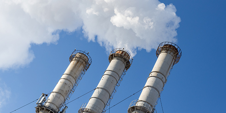 Smoking chimneys power against the blue sky