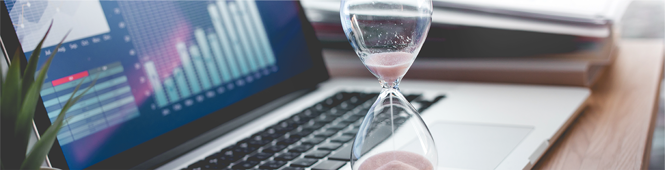 Hourglass in front of a laptop
