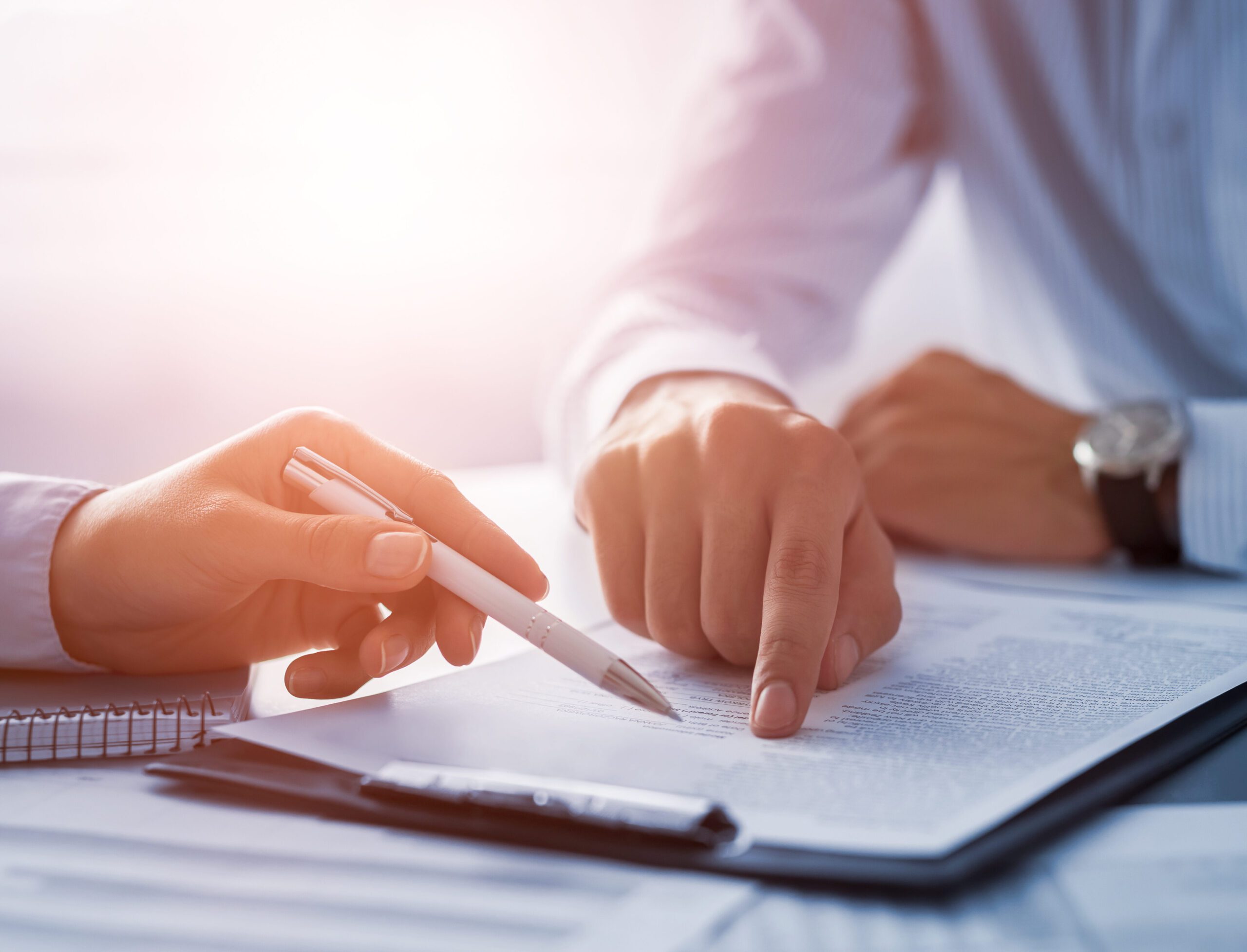 Business people negotiating a contract. Human hands working with documents at desk and signing contract.