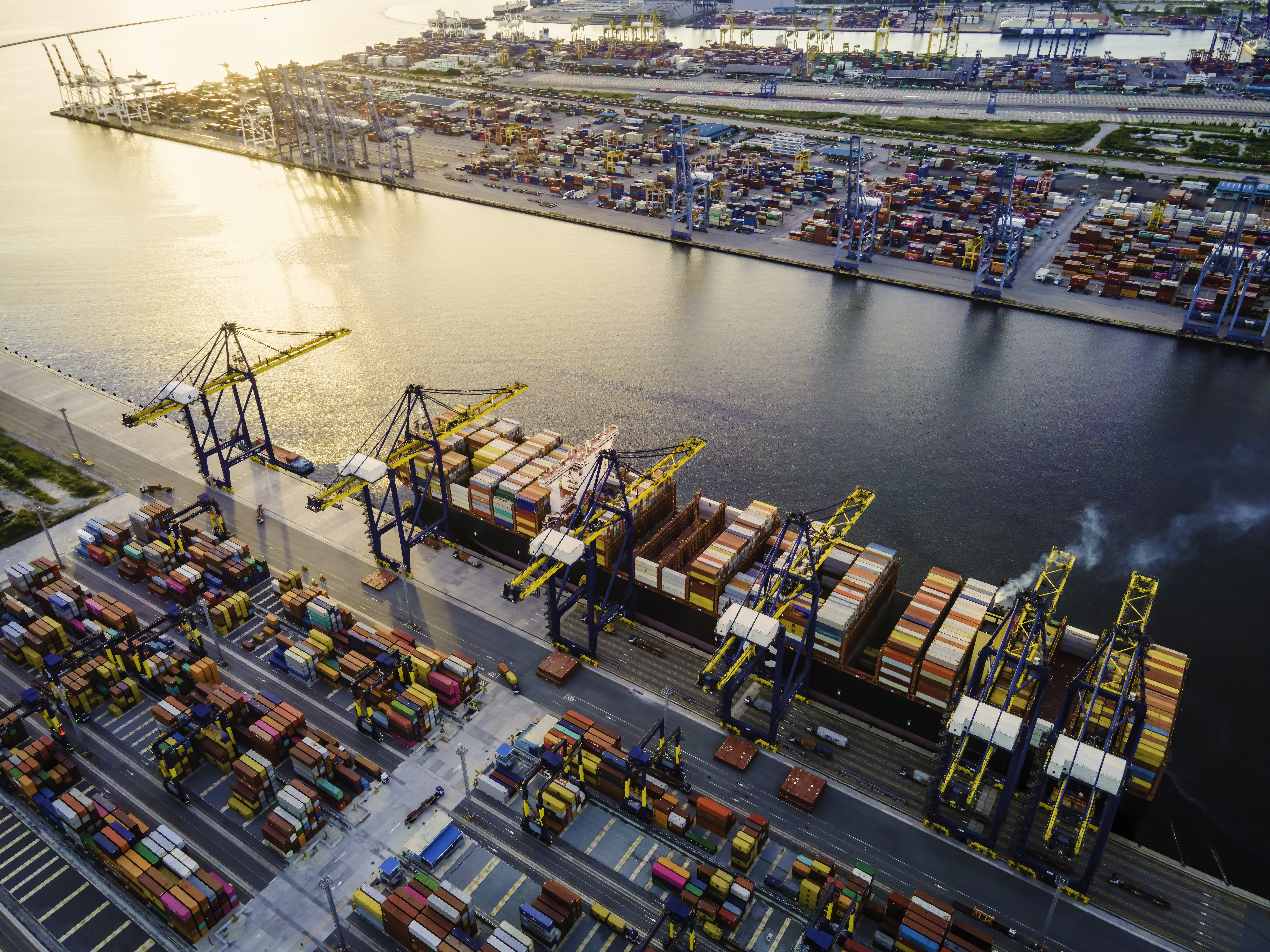 Shipping Containers on a large freight boat being moved by large cranes
