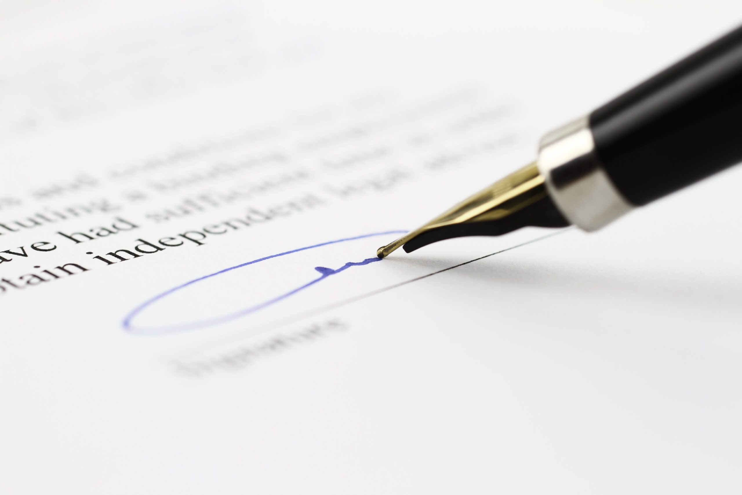 Pen signing the signature field of a document