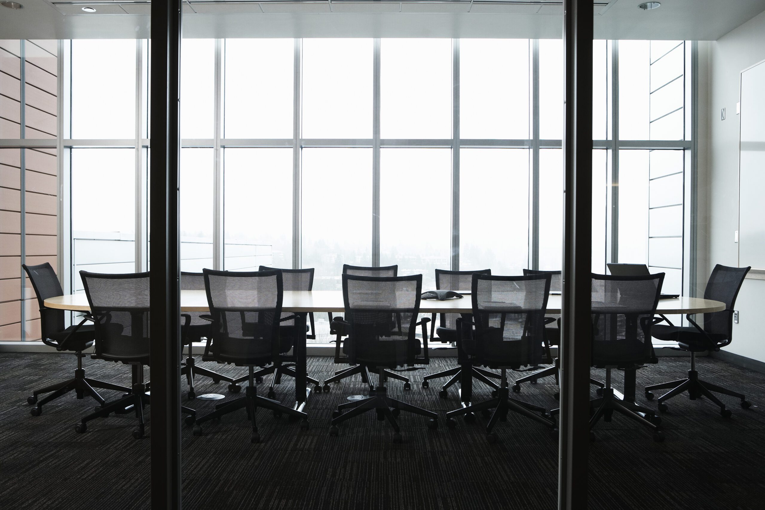 Empty boardroom with a large table surrounded by chairs